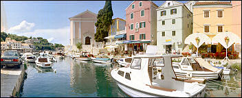 Blick aus dem Hafen von Veli Losinj - rechts die Pension Saturn und die Barockkirche des hl. Anton aus dem 17. Jahrhundert